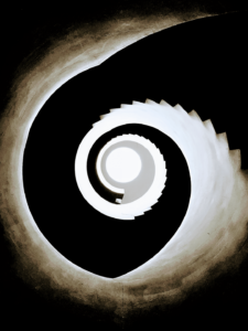 A high contrast image of black and white spirals that emerge as a spiral staircase leading downward. 